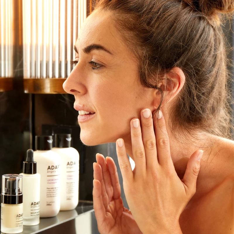 Crema Nutritiva Antiedad aplicada por una mujer sobre el rostro y el cuello, de ADAPTA Cosmetics